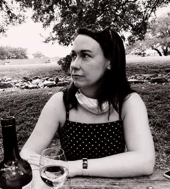 Picture of the author, at a vineyard with a glass of wine. 